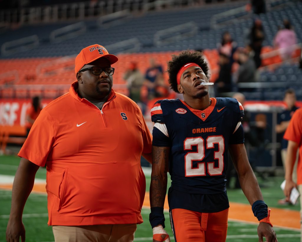 Syracuse defender walks into locker room getting consoled by coach