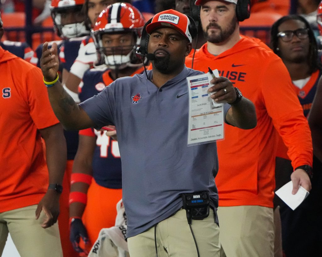 Syracuse University Football head coach Fran Brown on sidelines with arms in air